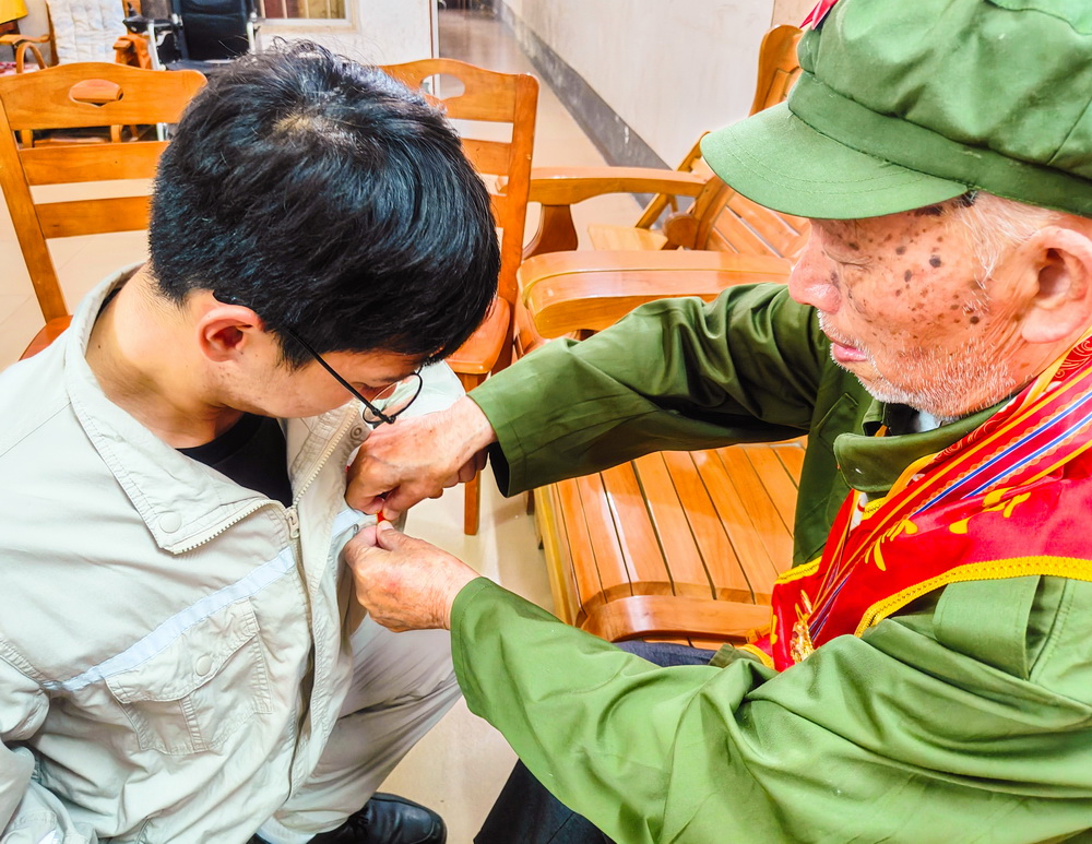 2、韋仕隆給新入黨的青年黨員佩戴黨章--李陽(yáng)攝.jpg